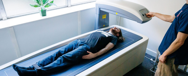 Photo of a man lying on a DXA scanner 